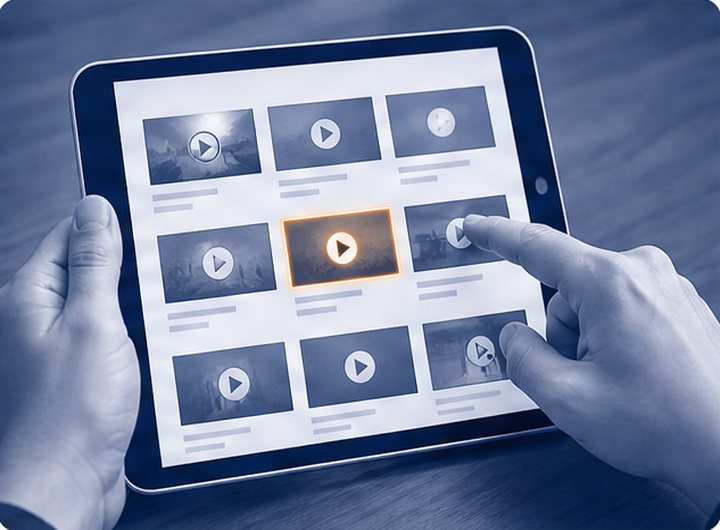 タブレットの動画のサムネイルを見比べる手元